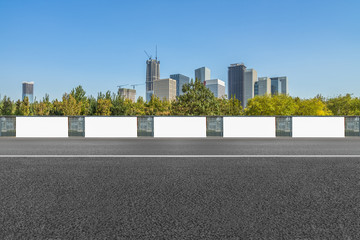 empty asphalt road and blank billboards front of modern buildings.