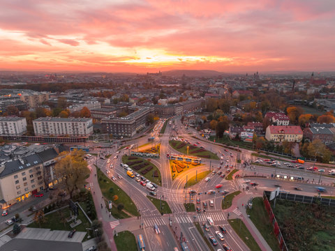 Aerial view of Krakow, Poland. Transportation, rush hour traffic, cars on highway interchange in city center. Sunset time, orange and gold light. Skyline, beautiful sky.