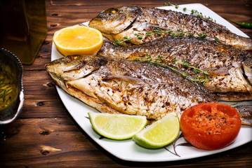 baked dorado \ dorada fish on a dark wooden background, top view