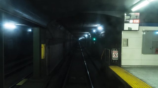 Timelapse of subway travelling at high speeds through tunnel and past stations