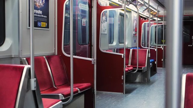 Artsy focus roll from the safety bar to red seats on an empty subway car