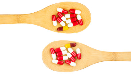 Colorful of antibiotics capsule pills in wooden spoon isolated on white background with copy space. Drug resistance concept. Antibiotics drug use with reasonable and global healthcare concept.