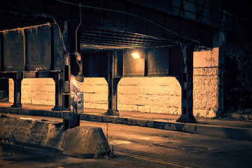 Fototapeta na wymiar Dark Chicago city alley industrial train bridge underpass at night.