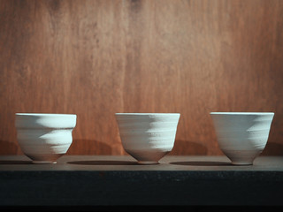 ceramic bowls on wood table over brown wooden background.