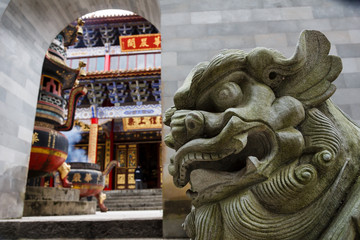 Stone dragon sculpture guarding entrance to Chinese Buddhist temple