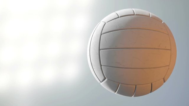 A volleyball ball caught spinning in slow motion flying through the air scattering dirt particles in its wake