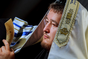 Jewish man blowing the Shofar horn of Rosh Hashanah New Year
