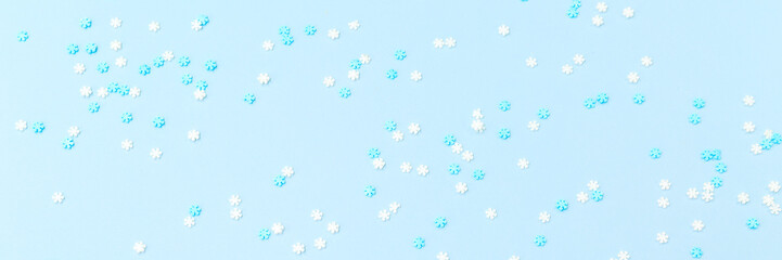 White and blue snowflakes sprinkles on blue. Festive holiday background. Celebration concept