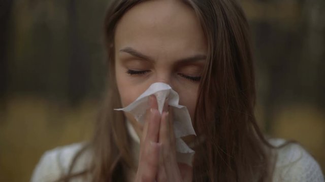 Woman suffering from runny nose, reducing immunity with onset of cold snap