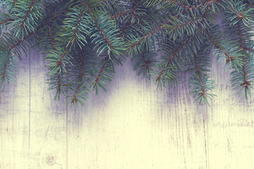 Christmas background. Christmas trees and Christmas decorations are on old light boards. Fir branches. Handmade decorations. Toned image. Space for text.