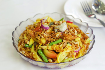 yellow mango salad with oyster and shallot garnish with crispy shallot