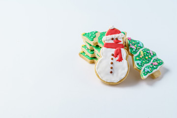 Festive Christmas snowman Cookie with decorated trees on white background.
