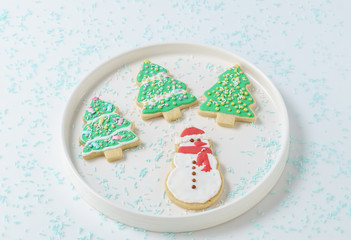 Festive Christmas snowman Cookie with decorated trees on white background.