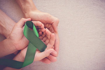 adult and child hands holding Green Ribbon, cancer awareness, Liver, Gallbladder Bile Duct cancer...