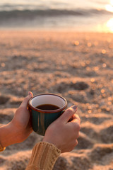 Female hands holding a mug with tea