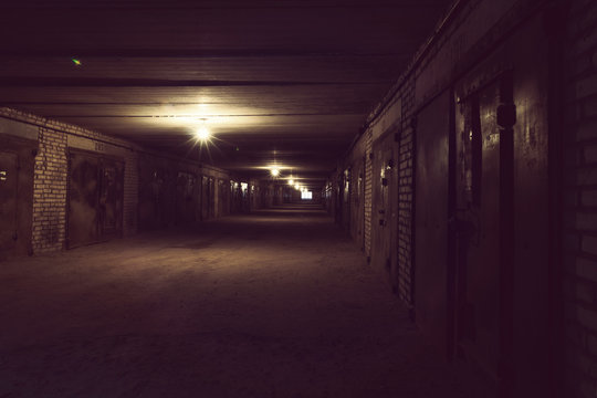 Dark long hallway with metal gates and working bulbs