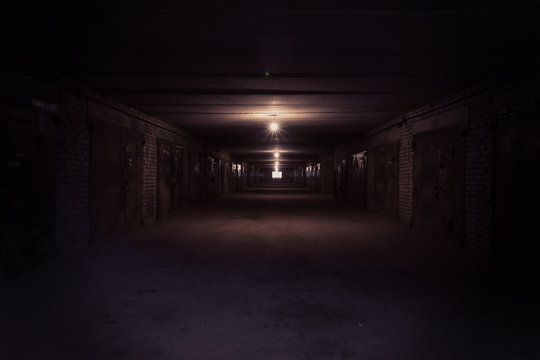 Dark long corridor with metal gates and working bulbs