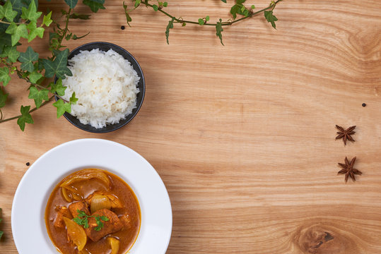 Chicken curry with spice on wooden background