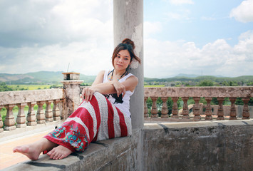 Fototapeta na wymiar girl sit in the old building escape from the hot sunshine on the kaiping watchtower