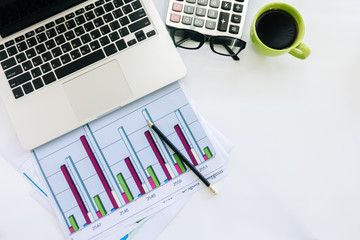 Businessman analyzing investment charts with laptop computer on office desk table.