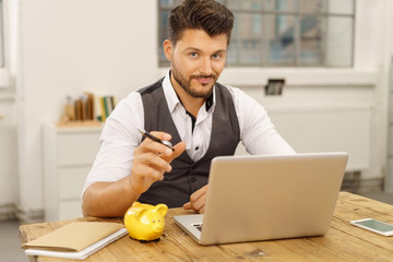 geschäftsmann mit laptop und sparschwein