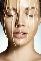 Fasion woman portrait with drops of liquid foundation on face.