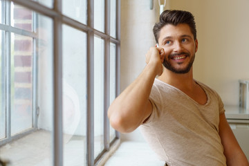 mann telefoniert und schaut lächelnd aus dem fenster