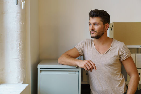 junger unternehmer schaut in gedanken aus dem fenster