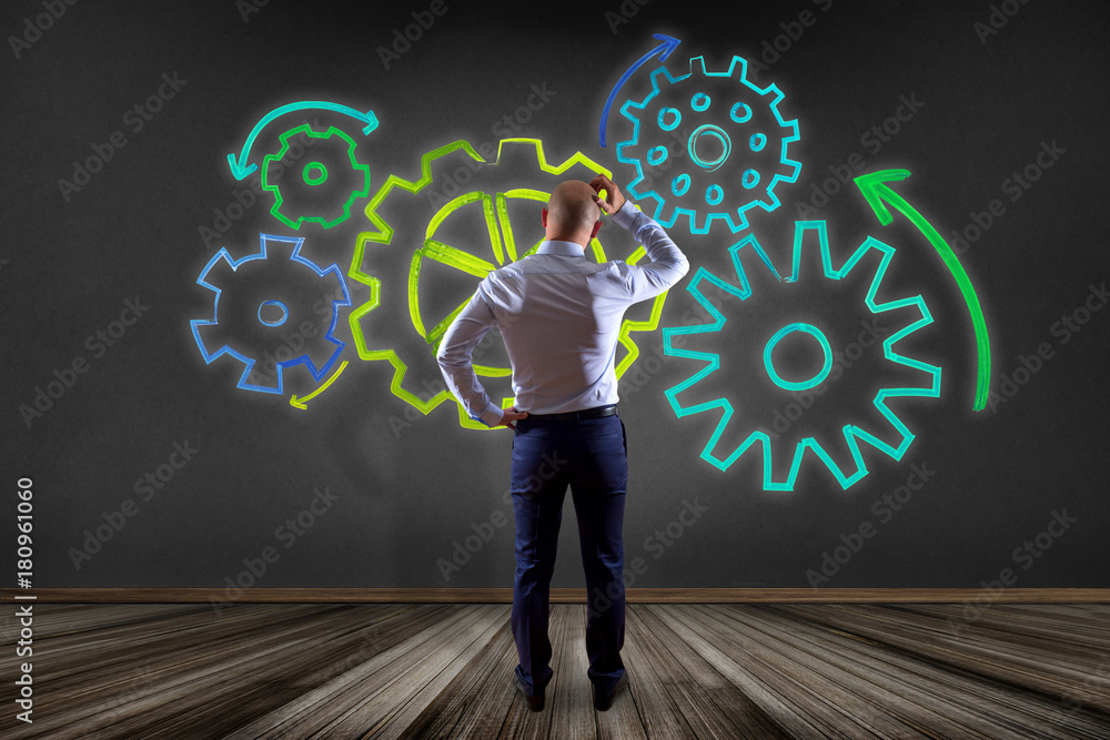 Aufkleber businessman in front of a wall with a cogwheel interface setting with different colors - technology 