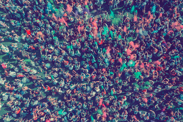 Crowd of people dirty in green and pink paints Holi