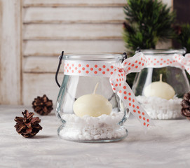 glass New Year candle holders with candles on a wooden white table, selective focus