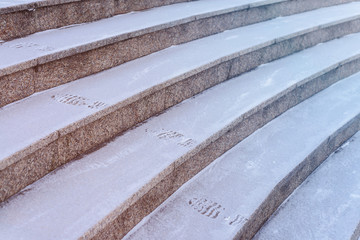 Footprints of shoes on the steps covered with a thin layer of snow