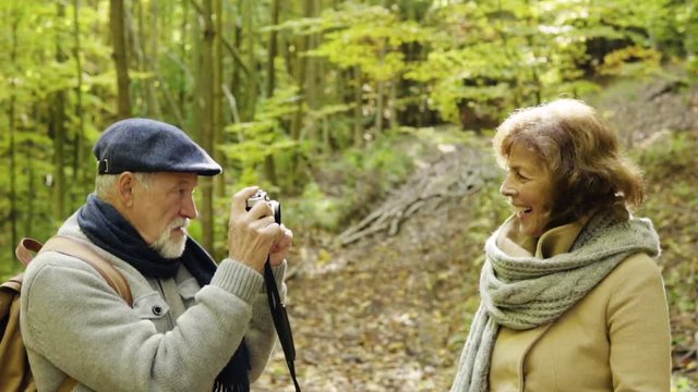 Senior couple on a walk in autumn forest.