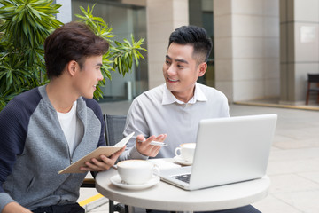 Handsome Asian business colleagues or college students work together using laptop, startup project...