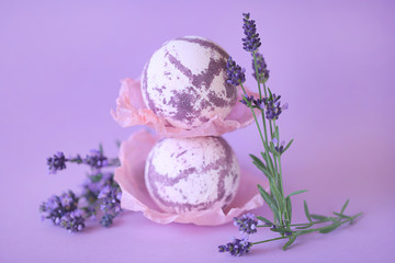bath bomb with lavender extract. two  lilac lavender bombs and twigs of lavender flowers on a...