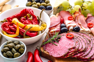 Spicy salami slices, ham and other tapas on table, food selection from spain, mediterranean diet
