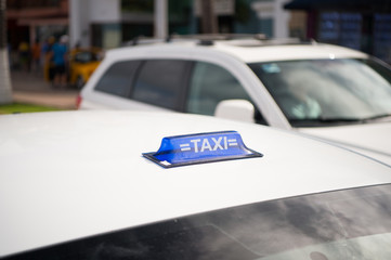 Taxi top sign on white cab roof