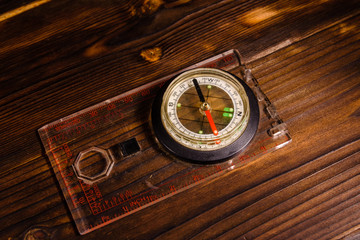 Touristic magnetic compass on wooden table