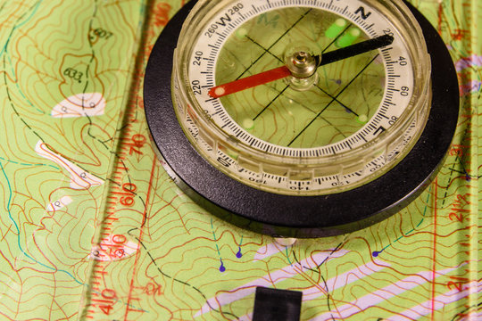 Magnetic compass lying on topographical map