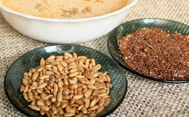 Cereals. Flax seed and sunflower seeds in green plates, standing on a natural linen napkin. Healthy nutrition for vegetarians, food in the Orthodox fast.