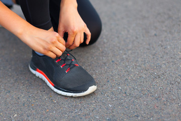 A teenage girl ties her shoelaces, prepares for a run