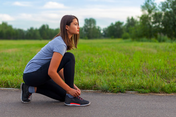 A teenage girl ties her shoelaces, prepares for a run