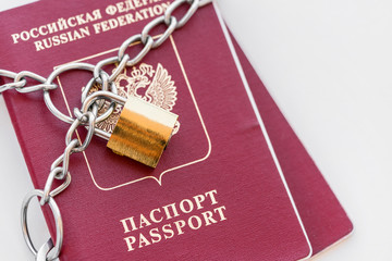 Two Russian Passports covered with a chain with a golden Lock on a white background. Isolated