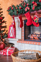 Basket with firewood near the fireplace with a Christmas tree and gifts on the eve of the new year