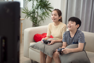 Obraz premium Asian woman with asian boy playing video games at home