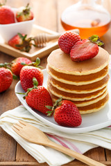 Mixed berry pancake with honey on wooden table