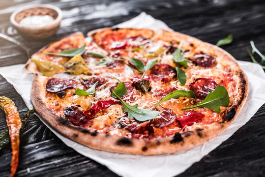 Delicious spicy pizza on wooden background