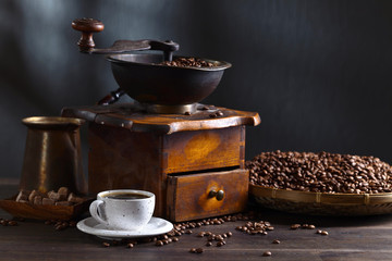 Cup of black coffee , coffee grinder and roasted beans