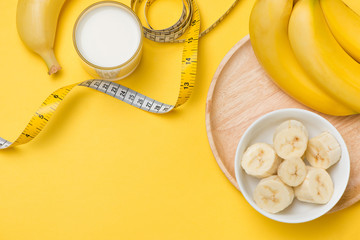 Healthy lifestyle concept - banana smoothie, measuring tape