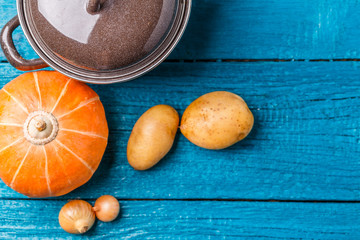 Image of pot with lid, potatoes, pumpkin, onions